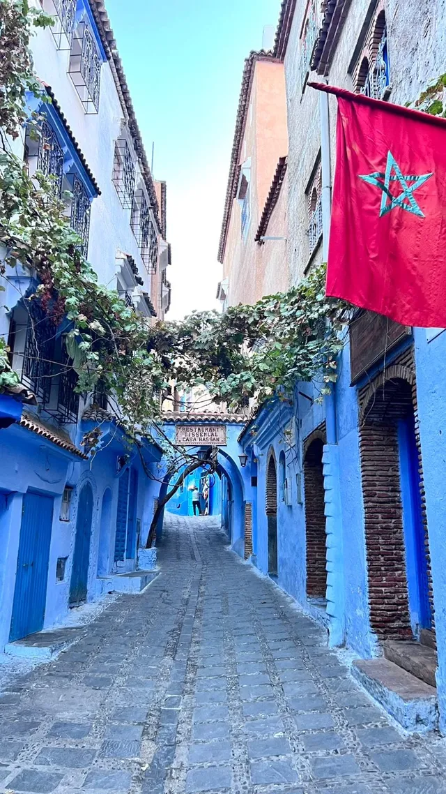 Ruela azul de Chefchaouen com a bandeira do Marrocos, norte do Marrocos